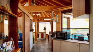 Une cuisine avec un sol en pierre, des poutres en bois et un four à micro-ondes.