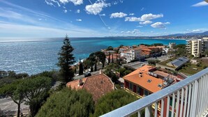 A coastal town with buildings, a clear sky, and a view of the sea. - Superb apartment with exceptional sea view (Nice)
