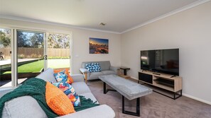 Een smart-tv, een tafeltennistafel, boeken en een stereo