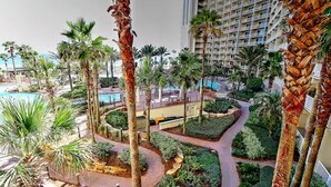 A resort with a pool, palm trees, and a landscaped garden. - Beach, Please! (Panama City Beach)
