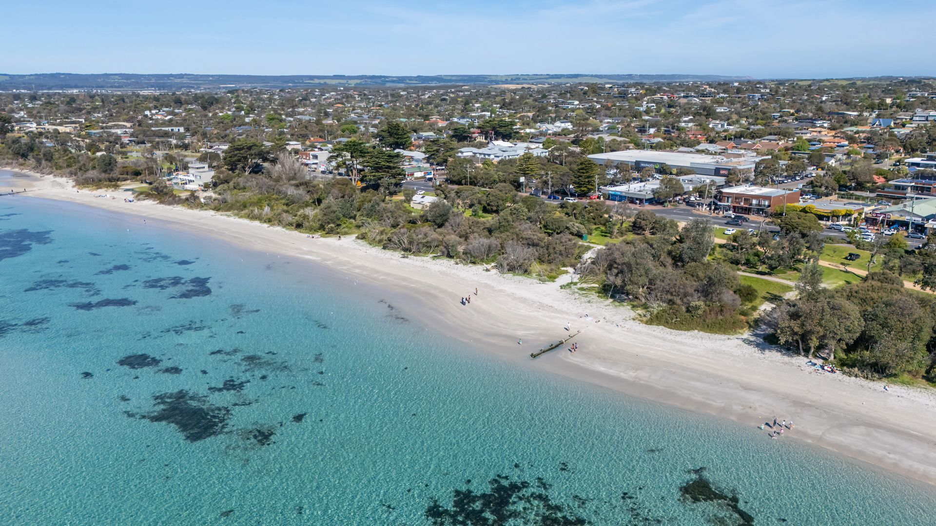 Una cittadina costiera con spiaggia, zone residenziali e edifici commerciali.