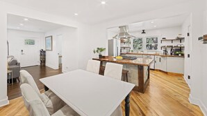 A modern kitchen with a central island, wooden flooring, and white cabinetry. - Chef's Kitchen; 2 King Beds with 55" TV's & Bunk Bed, 70" TV in Living Room (Atlanta)
