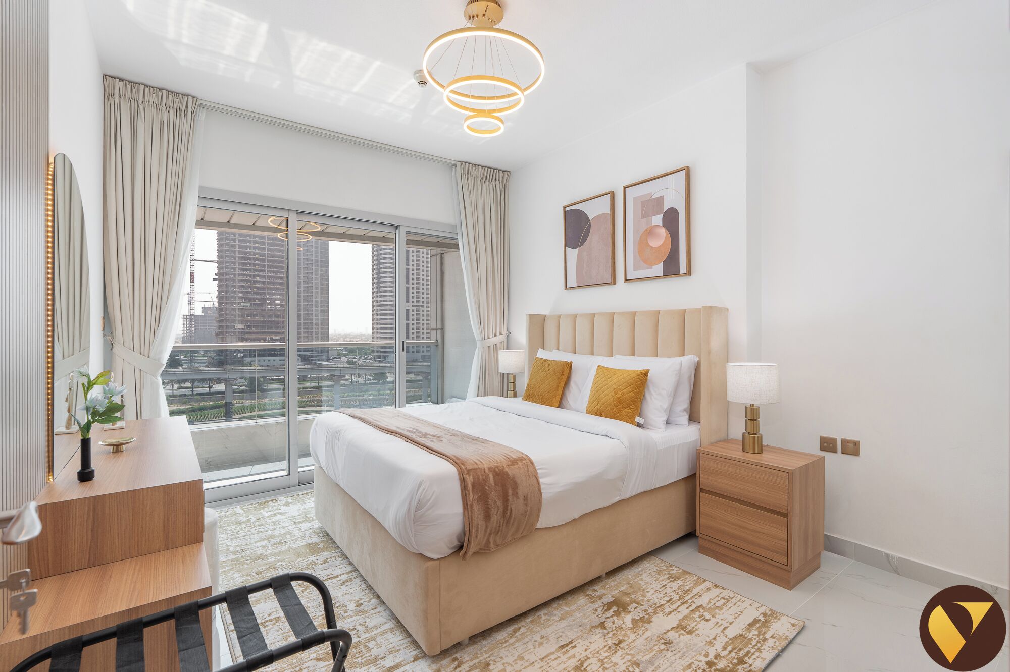 A modern bedroom with a large bed, bedside tables, a desk, and a chair.