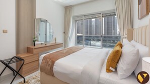 Une chambre d’hôtel moderne avec un grand lit, une table de chevet en bois, un miroir et une vue sur le paysage urbain par la fenêtre.
