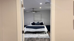 Une chambre à coucher avec un lit, un ventilateur de plafond et une fenêtre.