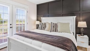 A bedroom with a bed, bedside lamps, a ceiling fan, and a view through a door. - Sauna, Theatre, Game Room, Gym, EV Chrger, Firepit (Toms Brook)