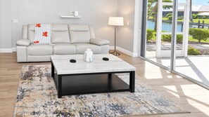Sliding glass doors connect this sunlit lounge to the terrace, with garden and canal views from the sofa.