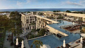 A modern hotel with a rooftop pool, multiple balconies, and a view of the ocean. - Ipana by The Spot Rentals (Playa del Carmen)
