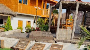 A swimming pool with wooden loungers and a person in the water. - Quinta Refúgio (São Domingos)