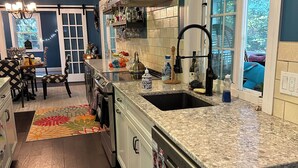 Una cocina moderna con una isla grande, electrodomésticos de acero inoxidable y vistas al exterior.
