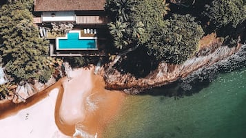 Na praia, espreguiçadeiras, guarda-sóis