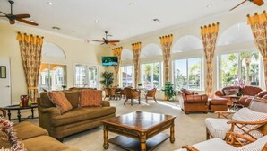 A spacious living room with a brown sofa, a wooden coffee table, and wicker chairs. - Enjoy all the Theme Parks and what Orlando has to offer at Terra Verde Resort! (Kissimmee)
