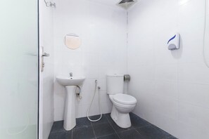 A small, clean bathroom with a toilet, sink, and shower.
