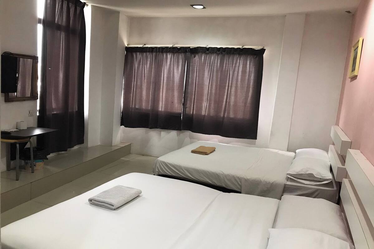 Een hotelkamer met twee bedden, een bureau en een spiegel.