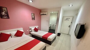 Ein Hotelzimmer mit zwei Betten, einem Fernseher, einer Klimaanlage und einem durchgegangenen Badezimmer.
