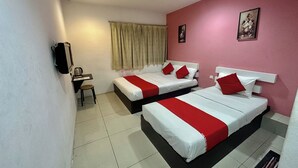 Ein Hotelzimmer mit zwei Betten, einem Schreibtisch, einem Stuhl und einem Fenster mit Vorhängen.