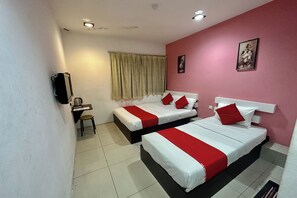 Une chambre d’hôtel avec deux lits, un bureau, une chaise et une fenêtre avec des rideaux.
