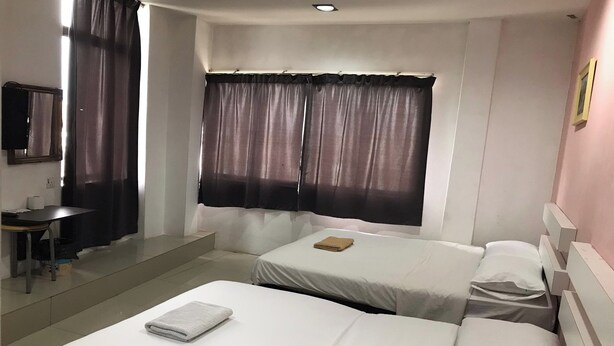 Ein Hotelzimmer mit zwei Betten, einem Schreibtisch und einem Spiegel.