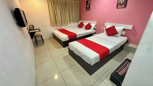 Ein Hotelzimmer mit zwei Betten, jeweils mit weißer und roter Bettwäsche, einem Schreibtisch mit Stuhl, einem Fenster mit Vorhängen und einem an der Wand befestigten Telefon.