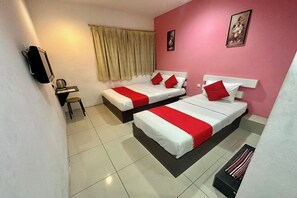 Une chambre d’hôtel avec deux lits, chacun doté de draps blancs et rouges, un bureau avec une chaise, une fenêtre avec des rideaux et un téléphone fixé au mur.