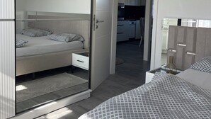 Ein modernes Schlafzimmer mit einem Bett, einem Nachttisch und einem Kleiderschrank.