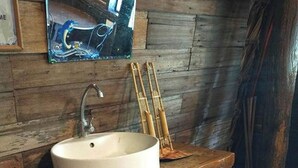 A rustic bathroom with a wooden sink and a vintage faucet. - Surfer's Villa La Union By Zuzu (San Juan)