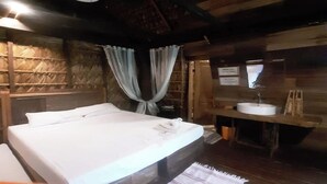 A wooden cabin-style room with a bed, a wooden bench, a sink, and a mirror. - Surfer's Villa La Union By Zuzu (San Juan)