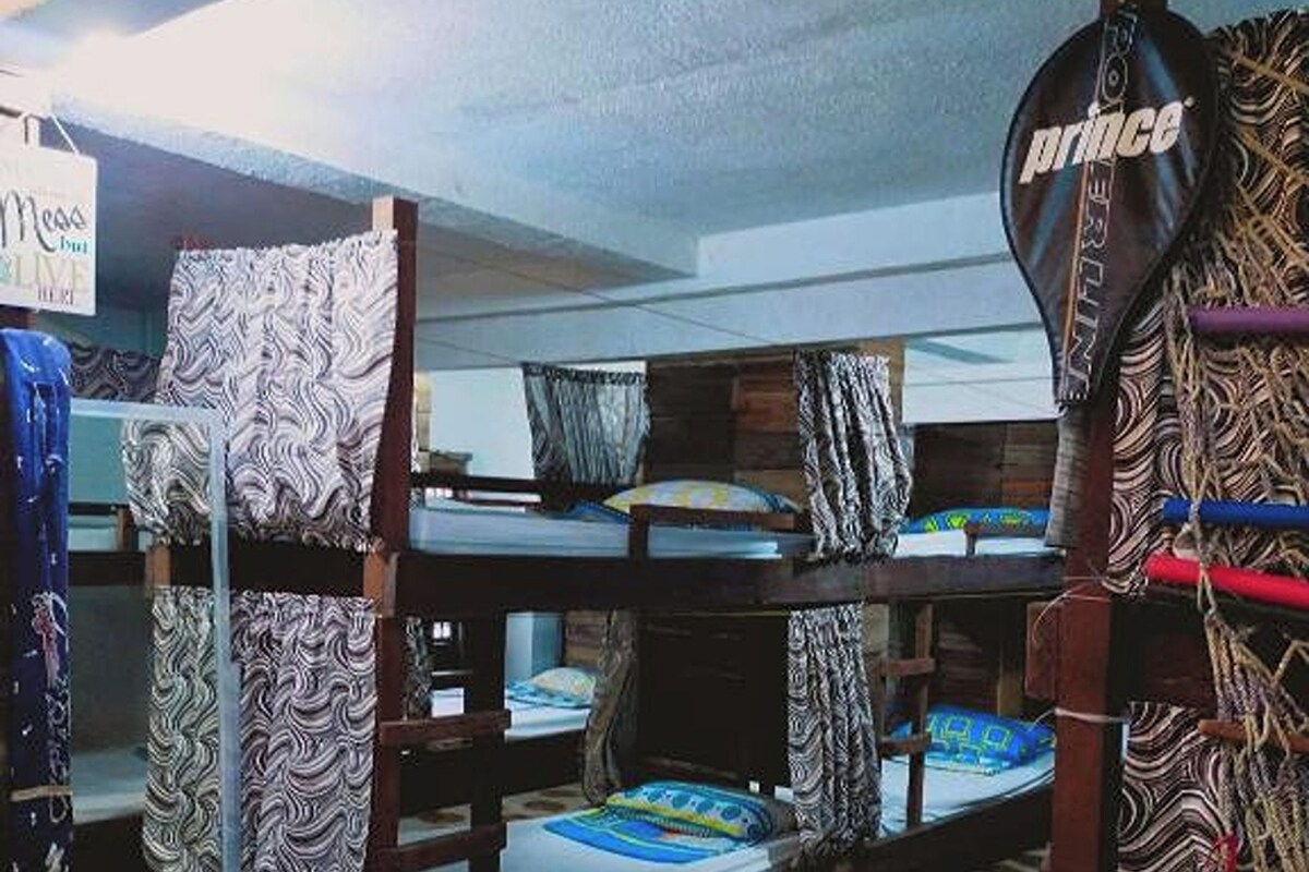 Una habitación con literas, cortinas estampadas y un cartel que dice 'Prince'.