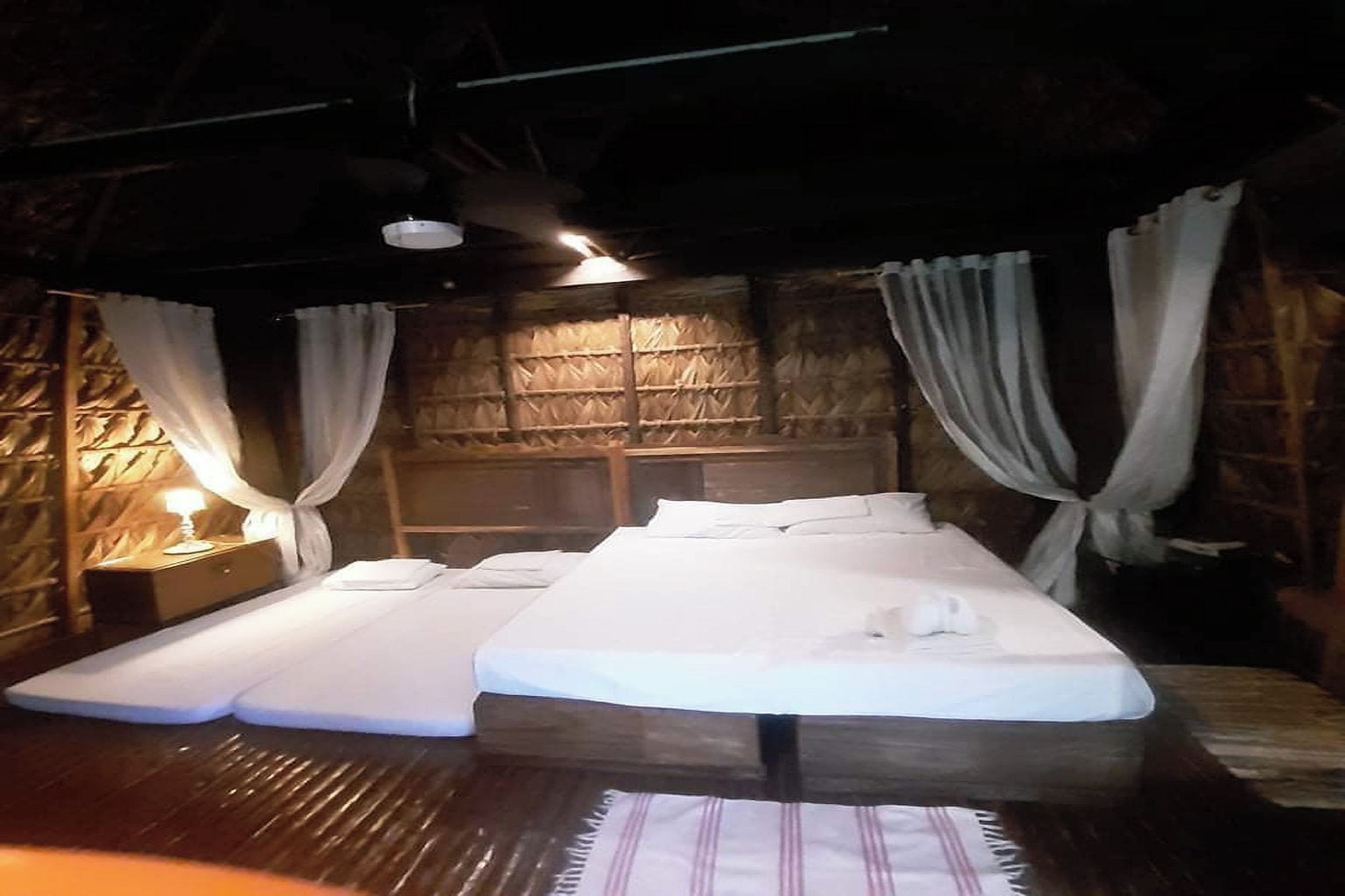 A room with a bed, two bedside tables, and a wooden wall.