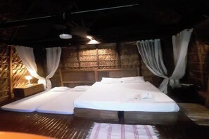 Una habitación con una cama, dos mesitas de noche y una pared de madera.