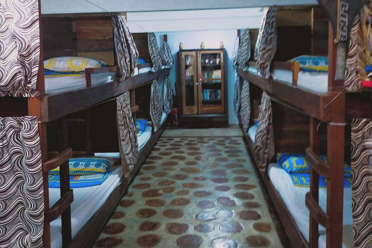 A dormitory room with bunk beds, a patterned floor, and a door labeled "Prince."