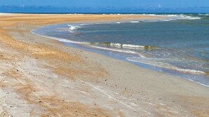 Egy tiszta, kék vízzel és homokos parttal rendelkező strand.