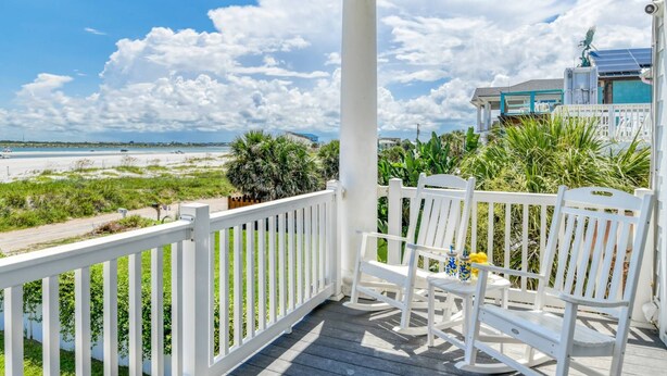 A wooden porch with white railings overlooking a beach. - A Pirate's Paradise (St. Augustine)