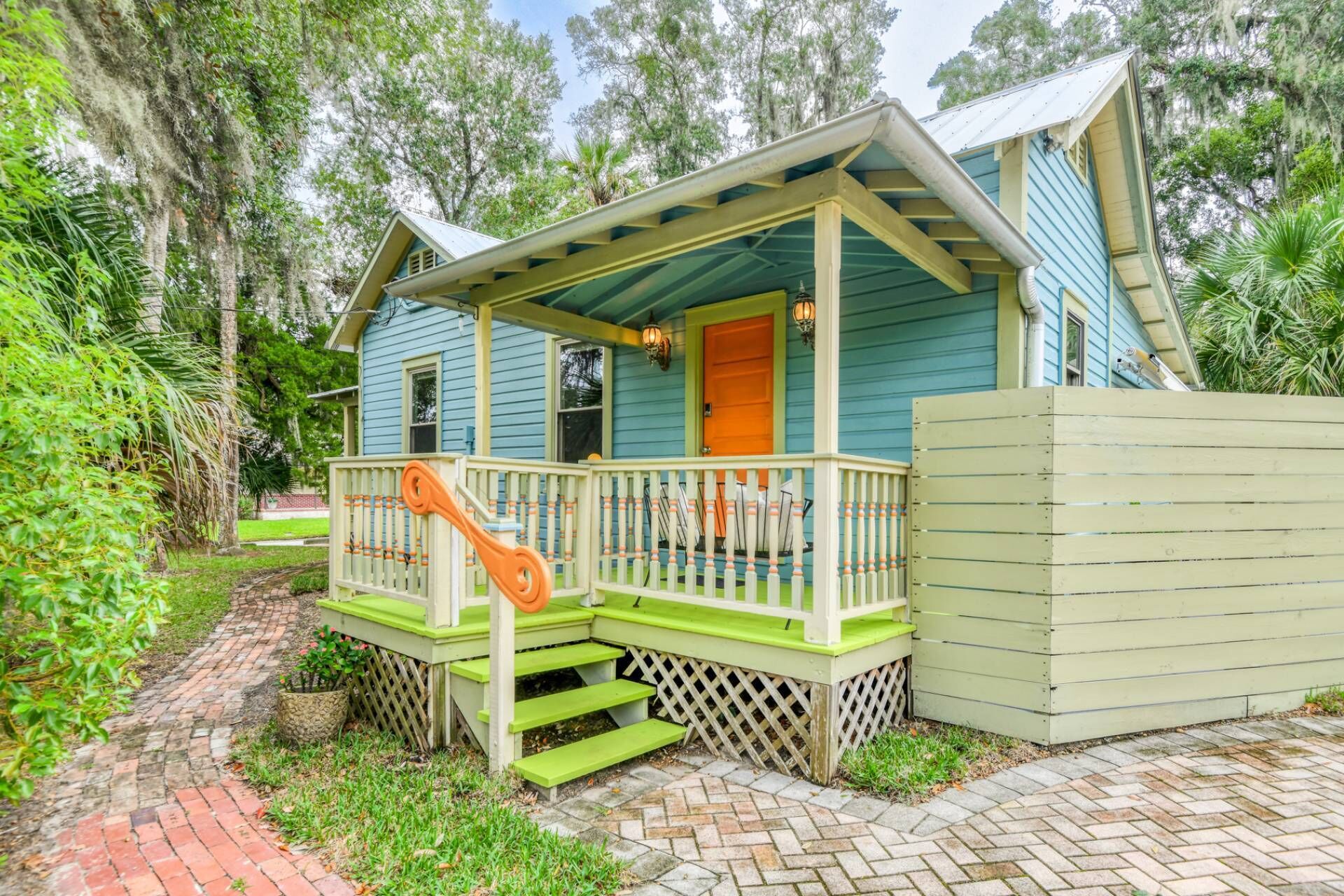 A house with a porch, a staircase, and a fenced area.