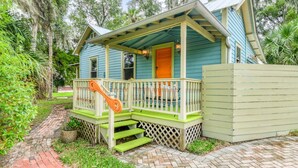 A house with a porch, a staircase, and a fenced area. - Little Blue Cottage (St. Augustine)