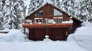 A wooden cabin with a balcony, surrounded by snow-covered trees. - Truckee Mountain Retreat + Trails + Pet Friendly (Truckee)