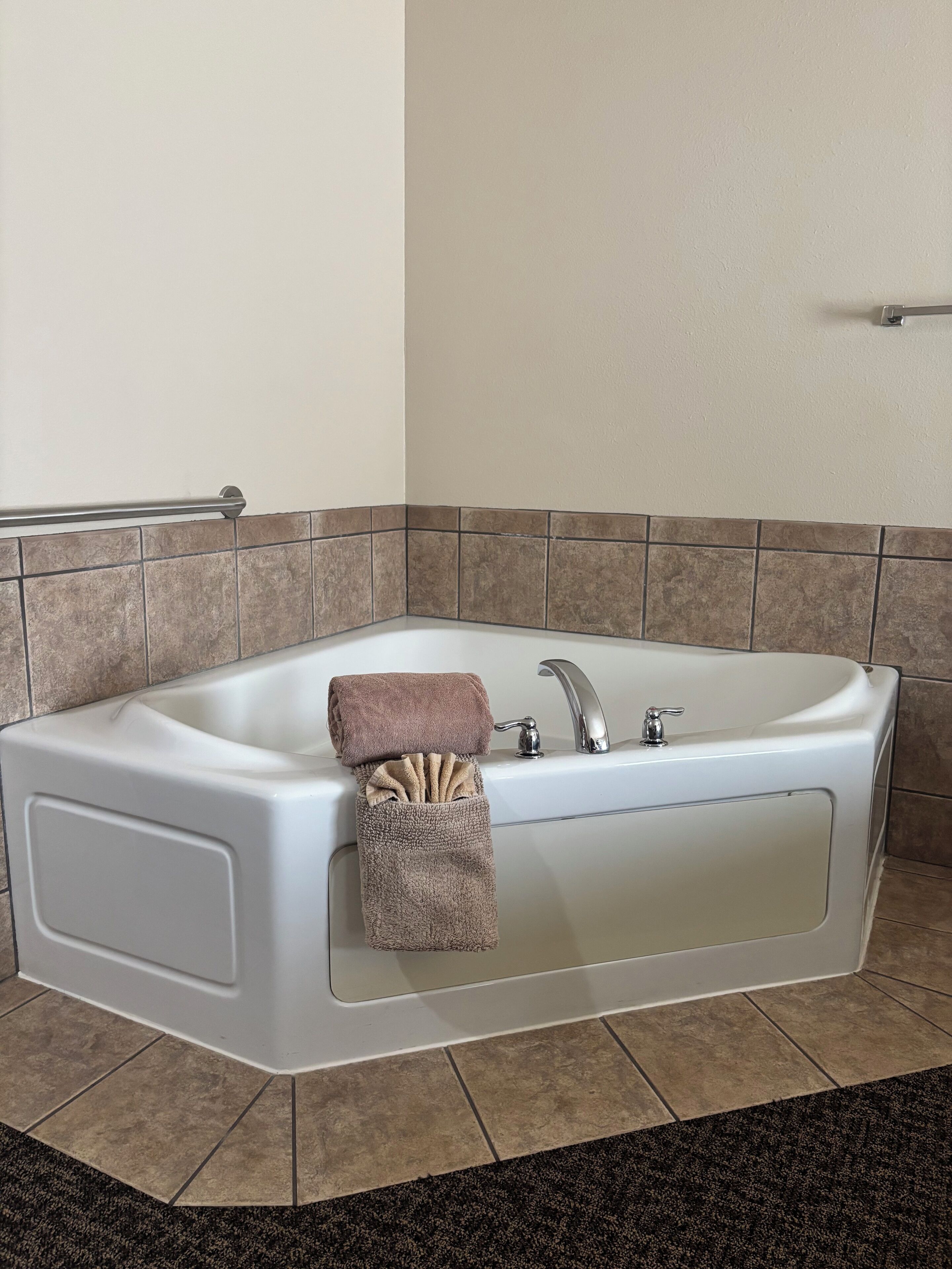 Ein modernes Badezimmer mit einer freistehenden Badewanne, einem Handtuchhalter und einer Handstange.