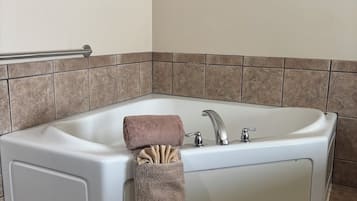 Ein modernes Badezimmer mit einer freistehenden Badewanne, einem Handtuchhalter und einer Handstange.
