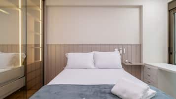 A modern bedroom with a bed, bedside table, and a wardrobe with a mirror.