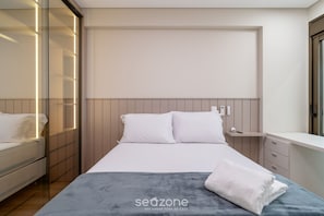 A modern bedroom with a bed, bedside table, and a wardrobe with a mirror. - Apart w/ 2 Suites in Jurere Internacional Vvc0202 (Florianópolis)