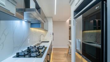 A modern kitchen with a gas stove, a built-in oven, and a microwave.
