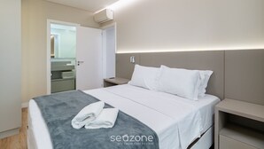 A modern hotel room with a neatly made bed, a bedside table, and a built-in shelf. - Apart w/ 2 Suites in Jurere Internacional Vvc0202 (Florianópolis)