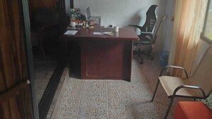 A room with a wooden ceiling, a desk with a computer, a chair, and a small couch. - Monteverde Monkey Hostel (Monteverde)