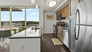 Een moderne keuken met een centraal eiland, roestvrijstalen apparatuur en uitzicht op de omgeving.