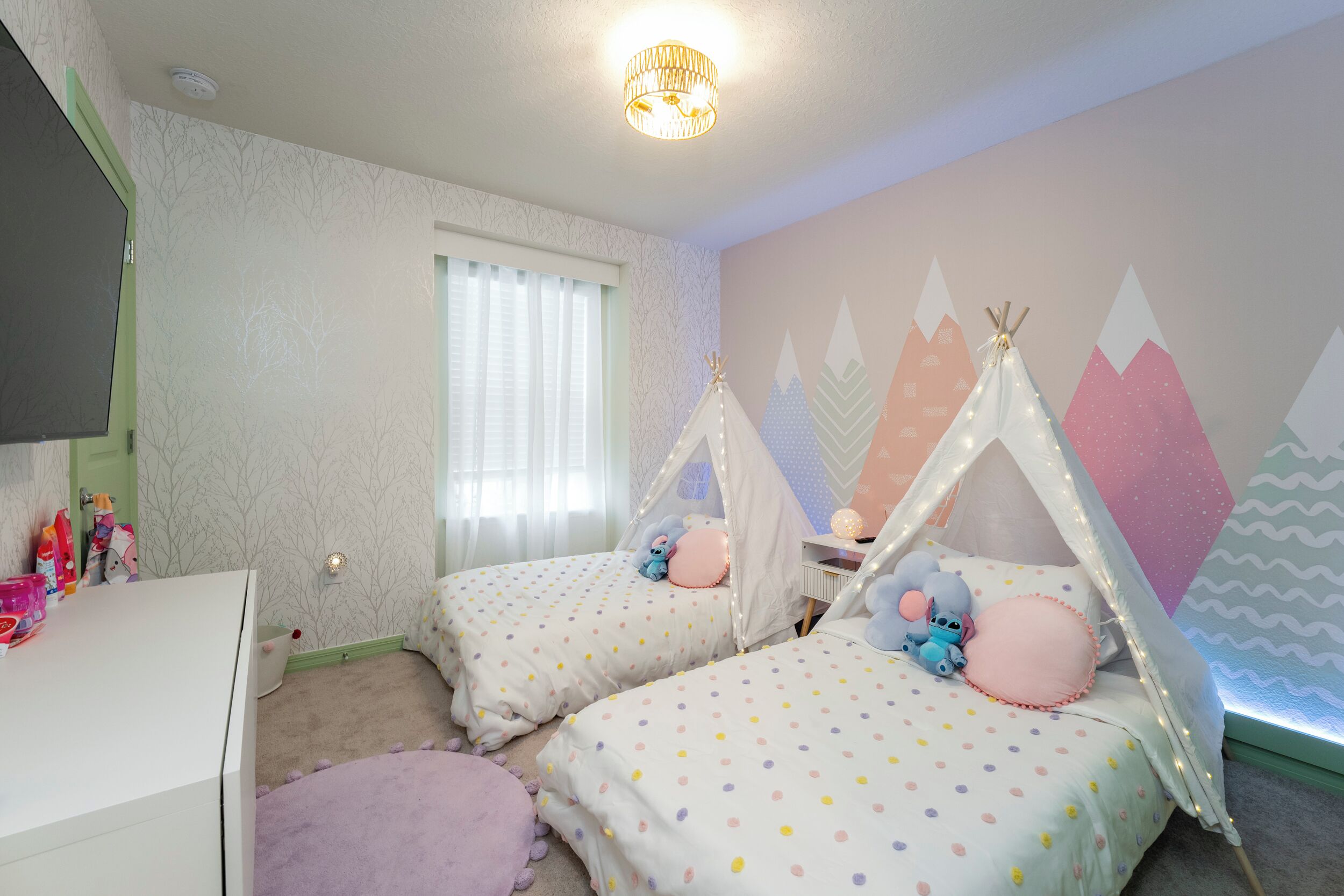 Una camera da letto per bambini con due letti, una cassettiera e una finestra con persiane.