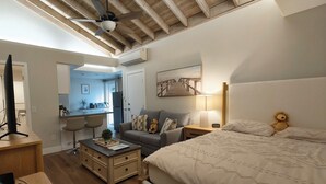 Una camera da letto accogliente con un letto, una scrivania, una sedia e un comodino.