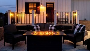 A patio with a fire feature, two wicker chairs, and a table. - Romantic Cottage /Book Now for Fall Foliage /2 King Suites/ Fireplaces/ Near JMU (Grottoes)