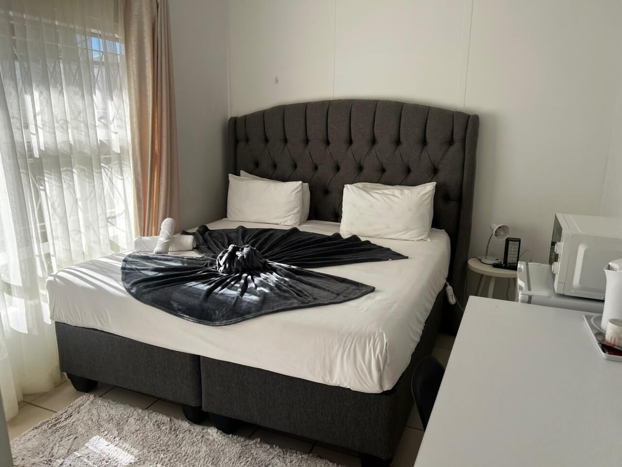 Camera Standard | Una scrivania, postazione laptop, tende oscuranti, ferro/asse da stiro