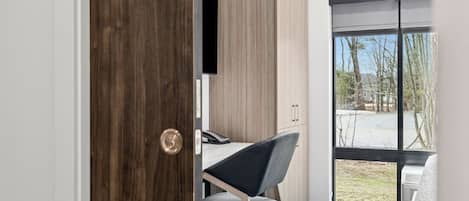 Une chambre moderne avec un bureau, une chaise et une grande fenêtre.