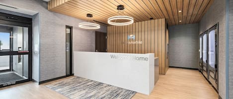 A reception area with a wooden ceiling, a reception desk, and a glass door entrance.